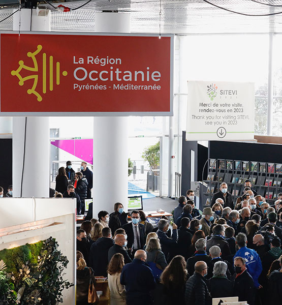 Panneau de la région Occitanie dans un hall avec des visiteurs