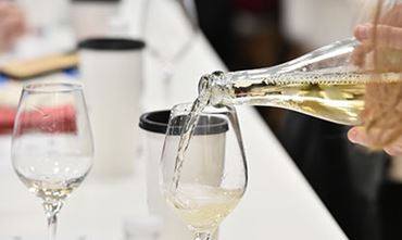 Femme versant du vin blanc dans un verre